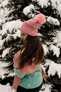 穿着粉红冬衣的黑发女人的肖像 在寒雪天和圣诞树下站在户外 冷杉 女性图片