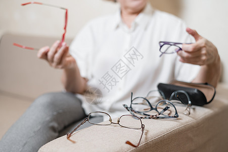 一位年长的白人妇女从她的家庭收藏中挑选眼镜 眼科医生 老年图片