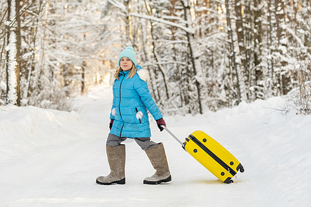 在寒冷的雪天 一个身穿脚靴的冬天女孩 带着手提箱去 火车 女士背景图片