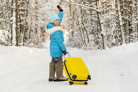 在寒冷的雪天 一个身穿脚靴的冬天女孩 带着手提箱去 霜 行李背景图片