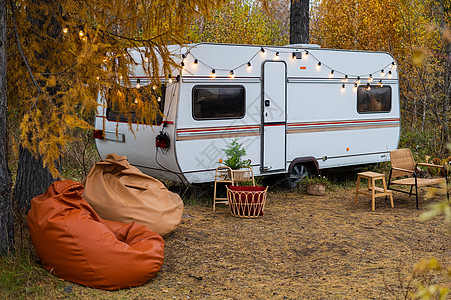 农村的野营或流动家庭 秋天森林里面包车旁边的舒适维基家具图片