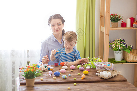 复活节概念 快乐的母亲和可爱的孩子准备迎接复活节 画了鸡蛋图片