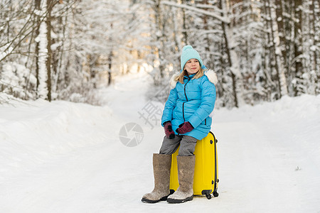 冬天 一个穿有感觉靴子的女孩 在寒冷的雪天坐在手提箱上 娱乐 关心图片