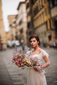 佛罗伦萨的新娘带着美丽的花朵图案作为面具 时尚的新娘穿着婚纱带着面具站在佛罗伦萨的老城区 佛罗伦萨的模特女孩 假期 欧洲图片