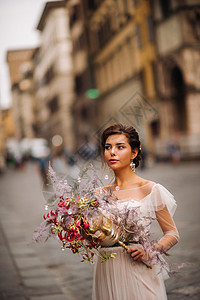 佛罗伦萨的新娘带着美丽的花朵图案作为面具 时尚的新娘穿着婚纱带着面具站在佛罗伦萨的老城区 佛罗伦萨的模特女孩 婚礼 微笑图片