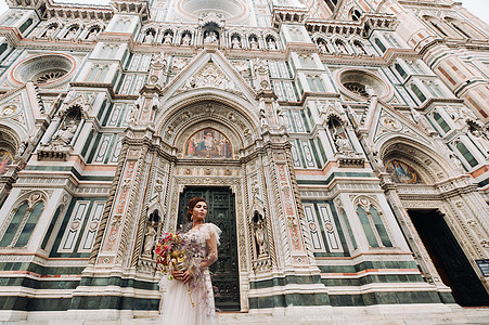 佛罗伦萨的新娘带着美丽的花朵图案作为面具 时尚的新娘穿着婚纱带着面具站在佛罗伦萨的老城区 佛罗伦萨的模特女孩 时髦 旅行图片
