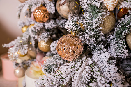圣诞树装饰着金色和粉色的玩具 圣诞装饰品 丝带 简笔画鹿 珠子和发光的花环 寒假 奢华的新年装饰 快乐的 庆祝图片