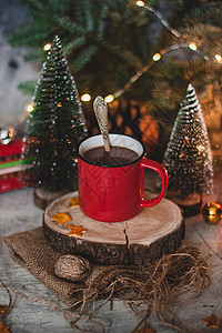 寒冷的冬天用红杯喝热巧克力可可 配有fir树 蜡烛和圣诞灯 甜点 舒适图片