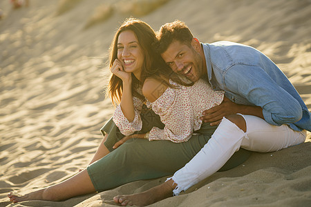 坐在海滩沙沙滩上欢笑的一对小情侣 白色的 男人图片
