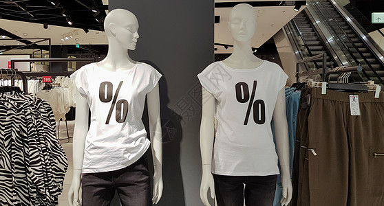 曼纳金人穿着白色T恤衫 在购物中心买东西时有百分位销售牌 宣传 广告 购物和黑色周五概念 背景上装饰图片