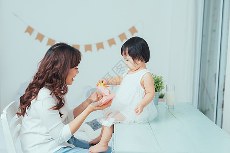 爸爸妈妈和孩子一起在快乐的单身母亲和好奇儿童女孩一起打开粉红礼物盒 假期 妈妈背景