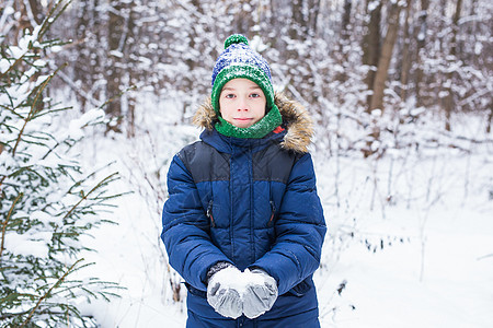 可爱的小男孩玩雪 玩得开心 微笑 冬季公园的少年 积极的生活方式 冬季活动 户外冬季运动会 雪球 围巾 雪橇背景图片