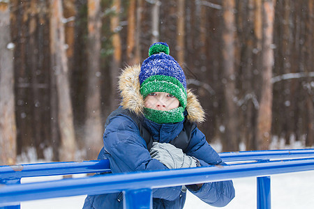 可爱的小男孩玩雪 玩得开心 微笑 冬季公园的少年 积极的生活方式 冬季活动 户外冬季运动会 雪球 滚雪球 美丽的背景图片