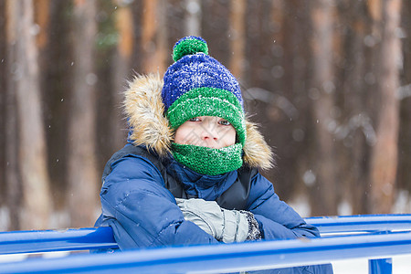 可爱的小男孩玩雪 玩得开心 微笑 冬季公园的少年 积极的生活方式 冬季活动 户外冬季运动会 雪球 男生 帽子背景图片