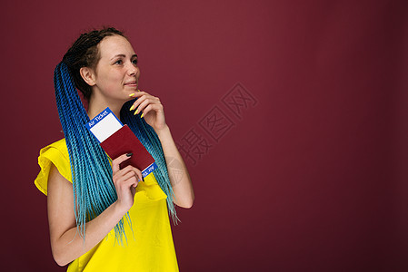 一位身穿黄色连衣裙 手里拿着机票和护照的现代时尚微笑女性 旅游理念 女孩 签证图片
