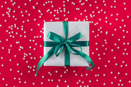 包在白纸上的礼物盒 上面有薄荷蓝弓和许多雪花的节日红礼背景背景图片