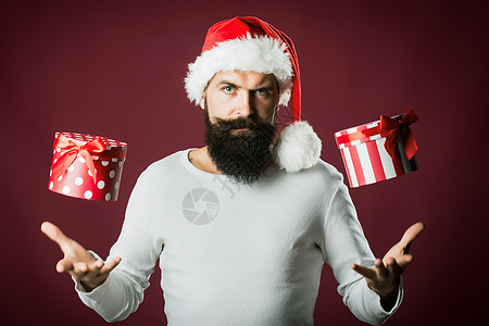 有胡子和胡子的圣诞老人拿着礼物 红色紫色背景的红紫色脸蛋图片