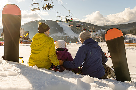 冬渡假度假胜地家庭有雪板 在雪中玩 蓝色的 孩子高清图片