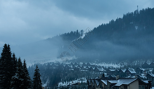 典型的山村在寒冬日白雪毯中沉没于寒冷的寒冬日图片