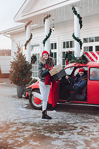 年轻夫妇给家人买圣诞礼物 然后用一辆红色的车送他们回家 蜜月 运输图片