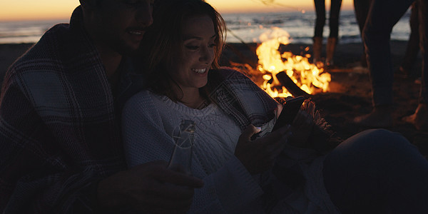 在海滩上和朋友一起享受营火的情侣 美丽的 旅行图片