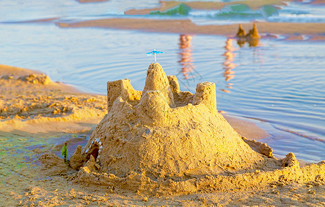 热带海滨沙滩上的沙城堡 童年 沿海 水 旅游 沙堡图片