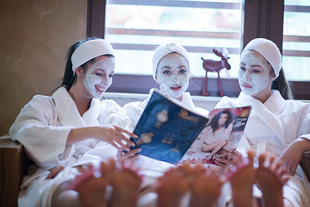 在温泉疗养会上单身派对 有面罩女孩阅读杂志 女孩们 快乐的图片
