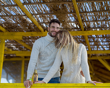 年轻情侣在海滩上一起喝啤酒 微笑 野餐 海岸线图片