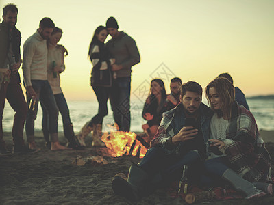 在海滩上和朋友一起享受营火的情侣 篝火 男人图片