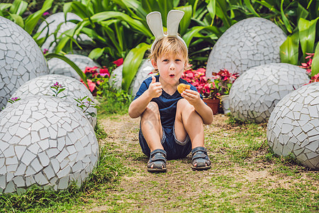 可爱的小男孩 长着兔耳朵 在户外玩传统的复活节彩蛋 庆祝复活节假期 蹒跚学步的发现 五颜六色的鸡蛋 自然 基督教图片