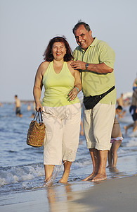老人散步快乐的老人情侣在海滩上 波浪 轻松 走 成熟背景