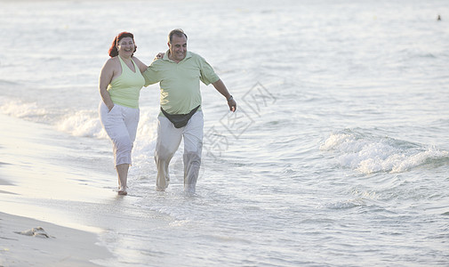 老人散步快乐的老人情侣在海滩上 漂亮的 日落 支撑 轻松 海洋背景