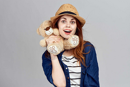 戴着帽子的开心女人 带着泰迪熊礼物玩具 甜的图片