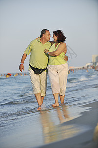老人散步快乐的老人情侣在海滩上 海洋 浪漫 爱 浪漫的 日落背景