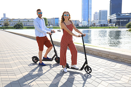 可爱的情侣在城市长廊上驾驶电动滑板车玩得开心 骑术 乐趣图片