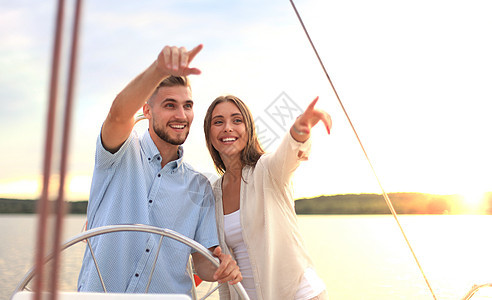 美丽的小情侣在游艇上站在一起时向远看图片