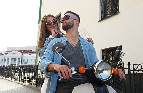 快乐的年轻夫妇骑着摩托车在城里 帅哥和年轻女子旅行 冒险和度假概念 微笑 户外图片