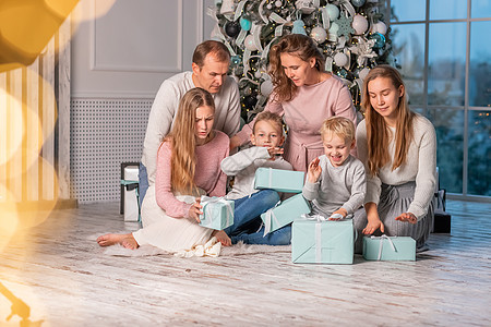 快乐的大家庭 有很多孩子在圣诞前夕在圣诞树下打开礼物 假期图片