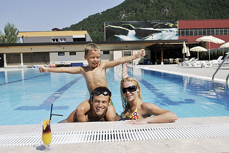 快乐的年轻家庭 在游泳池玩得开心 孩子们 女士图片