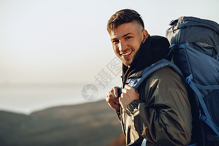 年轻的天主教男子旅行者 在山上徒步旅行 背着大背包在山上远足 地平线 冒险图片