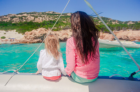 年轻妈妈和她可爱的小女孩 坐在一条大船上休息 快乐的 撒丁岛图片
