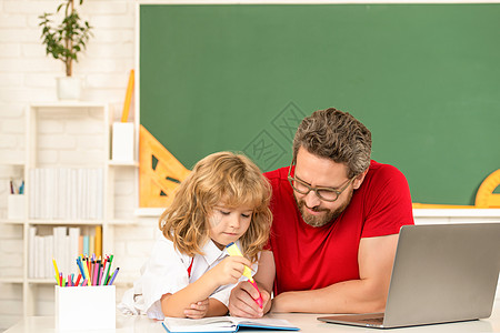 在线笔记本电脑教育 父亲和儿子使用现代通讯技术 并使用现代通信技术图片