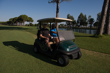 赛道上驾驶推车的高尔夫球运动员 夏天 课程 微笑图片