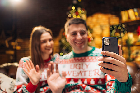 使用智能手机与家人交谈的年轻夫妇通过视频电话会议应用程序祝贺圣诞快乐 现代技术使用方便舒适 新的 2022 年祝贺远程概念图片