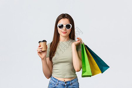 购物商场 生活方式 旅游和时装概念 穿墨镜 喝咖啡和购买衣服 持有外卖杯子和商店袋的无照护型妇女 时尚 店铺图片