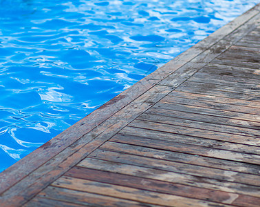 在露天游泳池中清澈的蓝水 泳池边缘图片