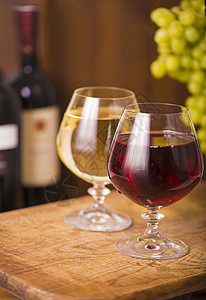 两杯葡萄酒 白红葡萄酒 还有木本底的葡萄图片