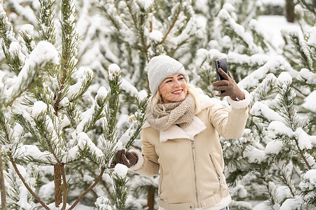 女人在冬天的冒险中 在雪地覆盖的森林里自拍 娱乐 旅游图片