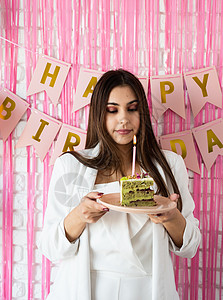 欢庆生日的美丽兴奋的女人 拿着蛋糕许个愿 女性 快乐的图片