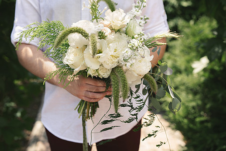新郎手中的一束美丽的白色和绿色花朵 夫妻 玫瑰图片